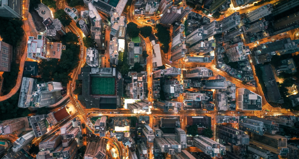 Aerial night view of a Dutch town centre with illuminated streets and rooftops, representing a municipality's digital footprint